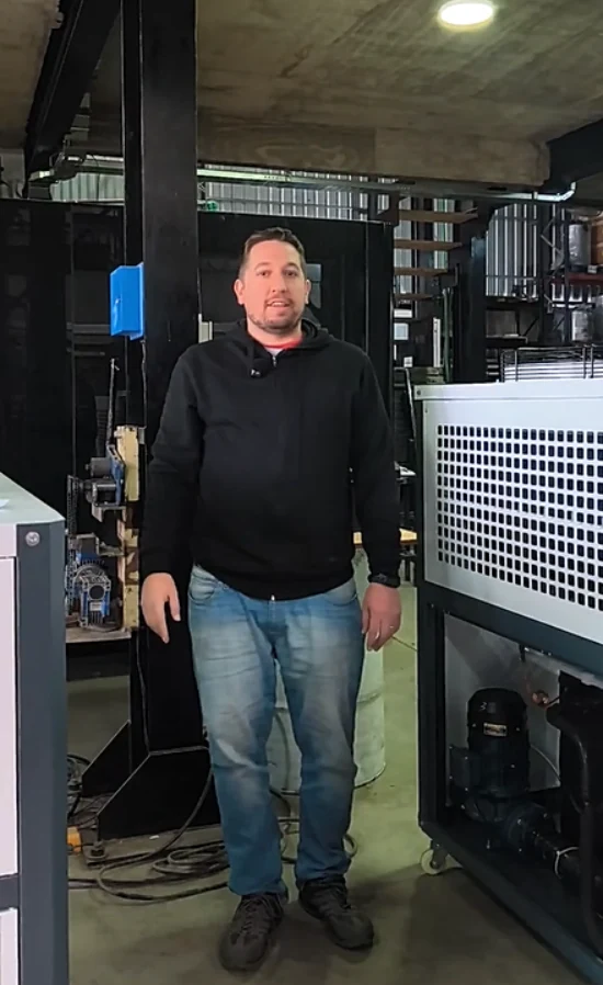 Cristián Polla junto a un chiller industrial en el taller
